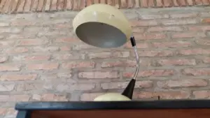 Lampada da tavolo vintage con paralume beige su fondo di mattoni