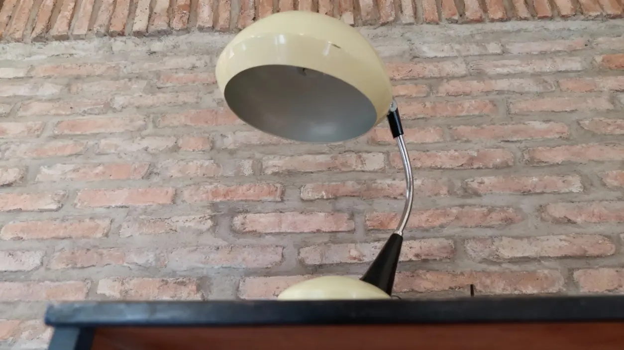 Lampada da tavolo vintage con paralume beige su fondo di mattoni